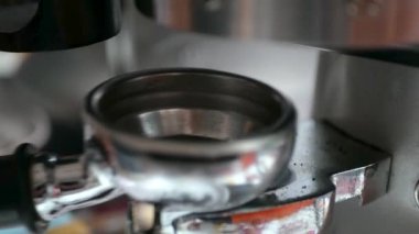 Kahveye yakın Portafilter kovası kahve öğütücüsünden kahve öğütücüsüne sabah içeceği için espresso yapmaya hazır kahve çekirdeğini doldurmak için.