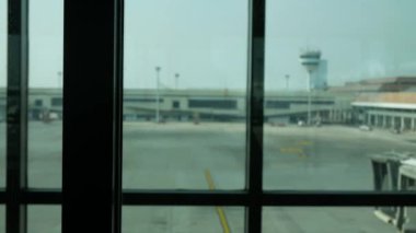 Görüntü bulanıklaştı. Gündüz vakti havaalanı terminalinin penceresinden uçak park alanına, ulaşım arka planı kavramına bakın.