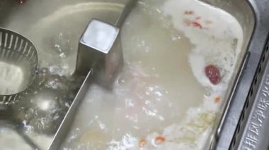 Çin usulü Shabu shabu 'ya 4k video POV. Yemek için sıcak tencereden dilimlenmiş domuz eti seçerken. Çin yemeği Japon yemeği.