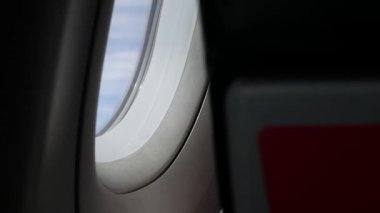 Ekonomi sınıfında koltuğun üzerinde güneş ışığı penceresinden uçağın penceresine doğru parlıyor, seyahat tatil ulaşımı arka planında