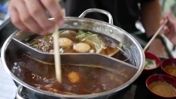 中国のスパイシーな鍋料理をしながら ミートボールを調理します 魚ボールと熱い沸騰中国語スタイルのスープ 家庭料理鍋家族の時間 — ストック動画