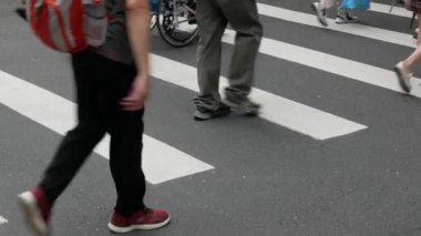 Taipei 'de gündüz vakti kalabalık bir motosiklet trafiği yaşanırken, kavşaktaki zebra kavşağındaki asfalt sokağa alçak açılı görüş.