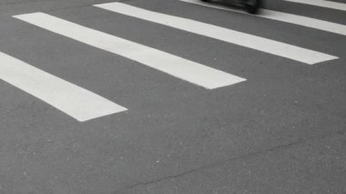 Taipei 'de gündüz vakti kalabalık bir motosiklet trafiği yaşanırken, kavşaktaki zebra kavşağındaki asfalt sokağa alçak açılı görüş.