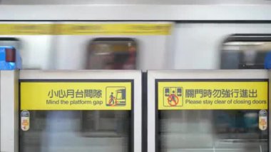 Metro metro metro istasyonundaki tren istasyonunda, tren istasyondan ayrılıyor ve metro platformu bariyerine odaklanıyor.