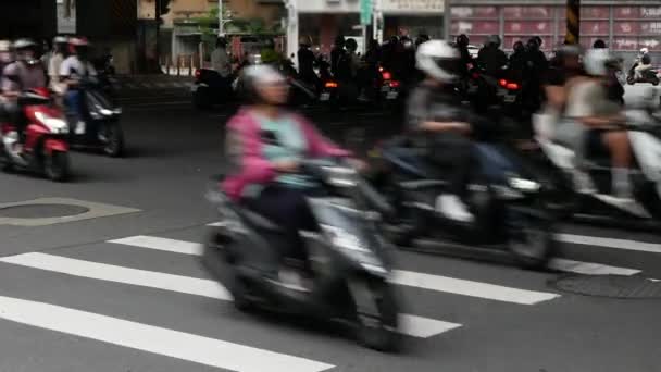 交差点のゼブラ交差エリアのアスファルトストリートへの低い角度ビューは 台北の昼間の都市生活に渡るバイクのオートバイの混雑した交通 — ストック動画