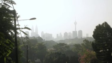 view local street leads into the downtown city center of Kuala lumpur in Malaysia with modern skyscraper building financial district and sunrise in the sky, KL city from hill