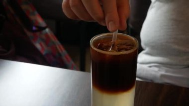 Limon suyunun üzerinde bir bardak taze buzlu kahveye yakın çekim yaparken en az kafede içki karıştırmak için saman kullanılıyor. Bir bardak buzlu içecek.