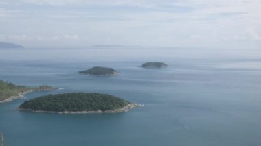 Yaz tatilinde tropikal okyanus denizi ve güneş ışığı altındaki adaların güzel doğal manzaralı deniz kıyısı manzarası yeşil çimen tarlası, Phuket, Tayland 'daki siyah kaya manzarası
