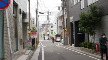 17 Kasım 2022 Fukuoka, Japonya.Arabalar ve insanlar Fukuoka 'daki Fujisaki bölgesinde günümüz reklam panoları ve reklam panoları olan binalar arasında gündüz trafiği yapıyorlar. Japonya 'da sokak manzarası