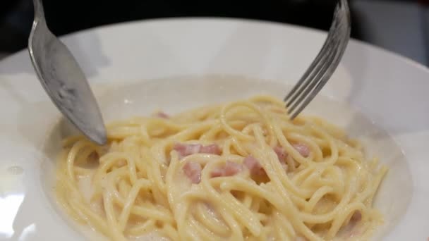 フォークとスプーンを使用して ディナータイムに自宅で新鮮な自家製スパゲッティホワイトソースパスタ 自家製スタイルでダイニングイタリア料理 パスタカボナラホワイトソースを食べる — ストック動画