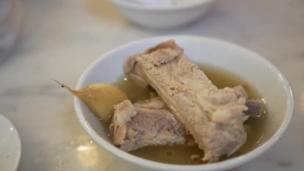 お昼ご飯の時間に熱いスープと一緒にお箸を使って豚の肋骨をバクーの茶碗からつかむ アジア シンガポール マレーシア風の熱いスープ 伝統文化 アジアのシンガポール料理 — ストック動画