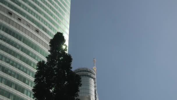 ビジネス街のモダンなガラスファサードオフィスビルのクローズアップ低角度定常ショット金融街の青い空とガラスの壁ミラー — ストック動画