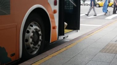 Temmuz 30,2023.Taipei, Tayvan. Otobüs durağına alçak açılı görüş, otobüs kapısına yakın, yolcu otobüsten inip otobüs durağında otobüse binerken. Taipei, Tayvan 'da toplu taşıma