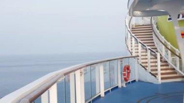 Yolcu yolcu gemisinin kıç tarafındaki boş güverte, yaz tatili tatilinde gün doğumunda uluslararası açık denizde seyahat ederken dinleniyor.