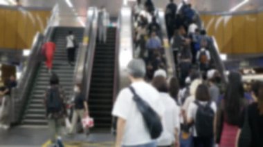 Kalabalık bir iş saatinde trenden indikten sonra metro istasyonunda yürüyen yürüyen yürüyen yürüyen yolcuların bulanık görüntüsü. Şehir toplu taşımacılığı.