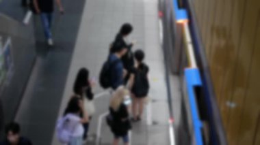 Odak dışı bulanıklık, metro istasyonunda bekleyen yolcuların yoğun iş saatinde trene binmeye hazır olduklarını gösteriyor. Şehir toplu taşımacılığı.