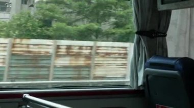 Tayvan 'daki Tayvan kırsalının yeşil manzarası dışında hızla hareket eden şehir otobüsündeki büyük camlı pencereye bakın. Tayvan toplu taşımacılığı