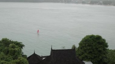 aerial view to a man while sailing in the sea when it is raining in phuket siray bay sea