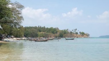 Berrak mavi gökyüzünün altında güzel tropikal bir deniz. Turkuaz denizler arasında yeşil bir ada. Yaz tatilinde bir teknesi ve yatı var. Phuket Cenneti Turizm Merkezi