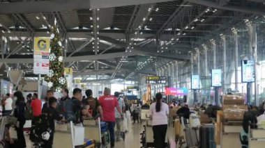 inside view of check in counter row area in international airport terminal with crowded passenger in Christmas New Year Festival Holiday season with decoration area
