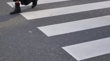 low angle view to the asphalt street at zebra crossing area at intersection while crowded of people pedestrian walking crossing ginza shopping street in Tokyo city of japan in winter day time