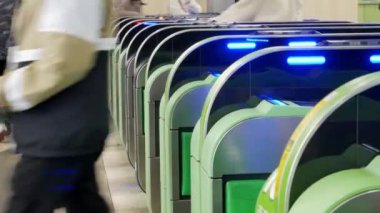Close up view of the ticket gate in the train station with many passenger get through the ticket gate in rush hour with RFID card in metropolitant big city of Tokyo