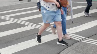 July25,2023.Taipei,Taiwan.low angle view to the asphalt street at zebra crossing area at intersection while crowded of people pedestrian walking crossing street in day time