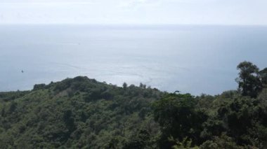 Yaz tatilinde tropikal okyanus denizi ve güneş ışığı altındaki adaların güzel doğal manzaralı deniz kıyısı manzarası yeşil çimen tarlası, Phuket, Tayland 'daki siyah kaya manzarası
