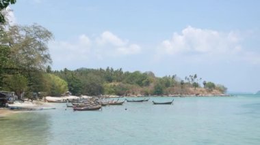 Berrak mavi gökyüzünün altında güzel tropikal bir deniz. Turkuaz denizler arasında yeşil bir ada. Yaz tatilinde bir teknesi ve yatı var. Phuket Cenneti Turizm Merkezi