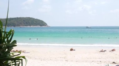Nisan 5.2023.Phuket, Tayland. İnsanlar yaz tatilinde, güneşli bir günde güneşli bir günde güneşli bir günde, tropik bir ada olan Phuket 'in beyaz kumsal deniz kenarında dinleniyorlar.