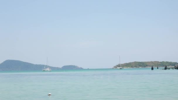 いくつかのボート 夏休みの時間にヨットとターコイズブルーの海の間で緑の島と澄んだ晴れた青い空の下で美しい熱帯の海 プーケットパラダイス観光地 — ストック動画