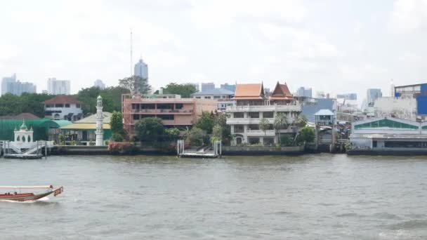 チャオプラヤ川のパノラマ風景水上ボート輸送と昼間の中央地区の間で多くの高層ビルが立ち並ぶバンコク市のスカイラインの背景 — ストック動画