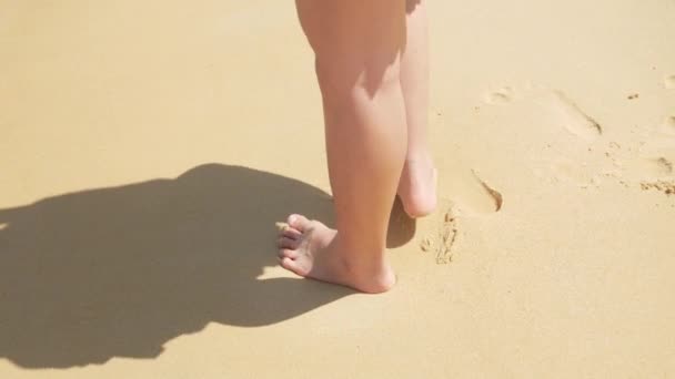 低角度ビューに裸足で白い砂浜に移動し 海からの波がビーチに当たると 夏は4Kの休暇の自然の背景をリラックスします ビーチでリラックス — ストック動画