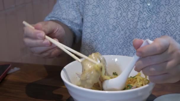 Θέα Έναν Ασιατικό Άνθρωπο Ενώ Χρησιμοποιώντας Chopstick Τρώνε Khao Soi — Αρχείο Βίντεο