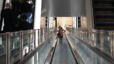 Ağustos 2023.Changi Singapur Havaalanı. Singapur 'daki Maxwell metro istasyonundaki yürüyen merdivene giderken bazı yolcularla birlikte. Şehir toplu taşımacılığı.