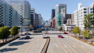 Chubu bölgesindeki Nagoya şehir merkezinde modern yüksek binalar ve cadde boyunca kalabalık yaya trafiği ile çevreleyen hava zaman kavramlı yol manzarası