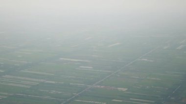 Tayland üzerinde gökyüzünde ince bir sis tabakası veya sis dumanı olan yeşil tarım alanı manzaralı uçan uçaktan gelen hava manzarası