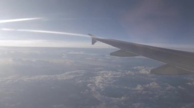 Gün batımında bulutların üzerinde gökyüzüne tırmanırken uçağın içeriden pencereyi seyretmek, doğal ulaşım tatil arka planı.