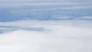 Mavi gökyüzü ve bulutlar bulutların üzerinden uçuyor. Güneşli bir günde, bulutlar yazın bulutların arkasında hareket ediyor.