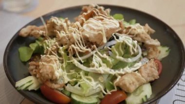 Bir kase sebze ve kızarmış yengeç kabuğuyla dolu salatadan salatalık kapmak için çatal kullanırdı. Japon sağlıklı yiyeceği.