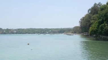 Berrak mavi gökyüzünün altında güzel tropikal bir deniz. Turkuaz denizler arasında yeşil bir ada. Yaz tatilinde bir teknesi ve yatı var. Phuket Cenneti Turizm Merkezi