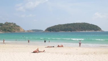 Nisan 5.2023.Phuket, Tayland. İnsanlar yaz tatilinde, güneşli bir günde güneşli bir günde güneşli bir günde, tropik bir ada olan Phuket 'in beyaz kumsal deniz kenarında dinleniyorlar.