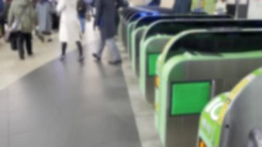 Tren istasyonundaki bilet kapısının görüntüsü bulanıklaştı. Çok sayıda yolcuyla birlikte büyük şehir Tokyo 'daki RFID kartıyla bilet kapısından geçiyor.