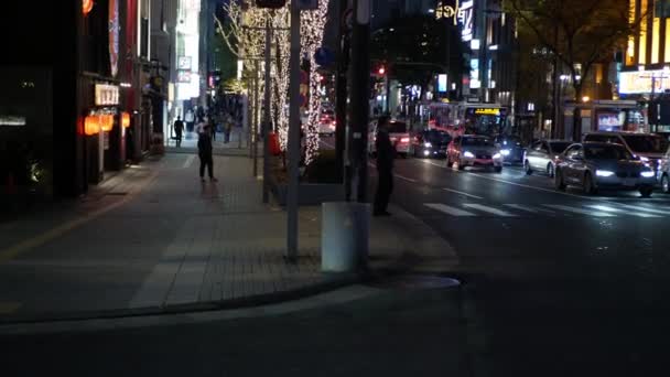 広告看板や看板のある近代的な建物の中で 福岡市内の昼間の車や人の往来 日本のストリートビュー — ストック動画