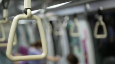 Seçici bir odak noktası ile yakın görünüm metro trenin trabzan tutun şehir toplu taşımacılık. Bir metro içi boş bazı yolcular ile metro trenin içi..