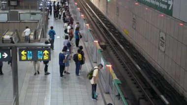 July26,2023.Taipei,Taiwan.top down view of crowded passenger get on and get off from subway train while train arrive and depart from platform in rush hour at taipei underground train station