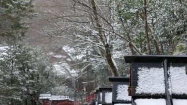 Japonya 'nın Kyoto Dağı' ndaki Kurama tapınağındaki kayalık merdiven yolu boyunca geleneksel ahşap fenere kar yağıyor. Eski Budizm mimarisi kışın şiddetli kar yağışının arasında inşa ediliyor.