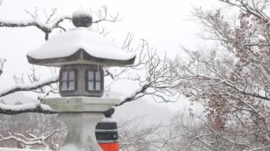 Japonya 'nın Kyoto Dağındaki Kurama Tapınağı' ndaki kaya fenerine ilk kar yağıyor. Kyoto Japonya 'daki eski Budizm mimarisi yoğun kar yağışı altında harika bir kış geçiriyor.