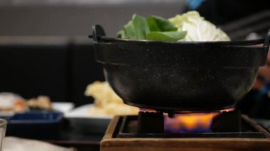 Japon Shabu Shabu için Pov 'dan kişisel güveç Japon restoranında kişisel fırında haşlanırken doğranmış biftek ve sebze, Asya yemeği.