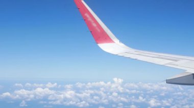 Güneşli bir günde gökyüzünde uçarken kanat manzaralı uçağın içini görmek, mavi gökyüzü seyahat tatil arka planına sahip uçak kanatları.